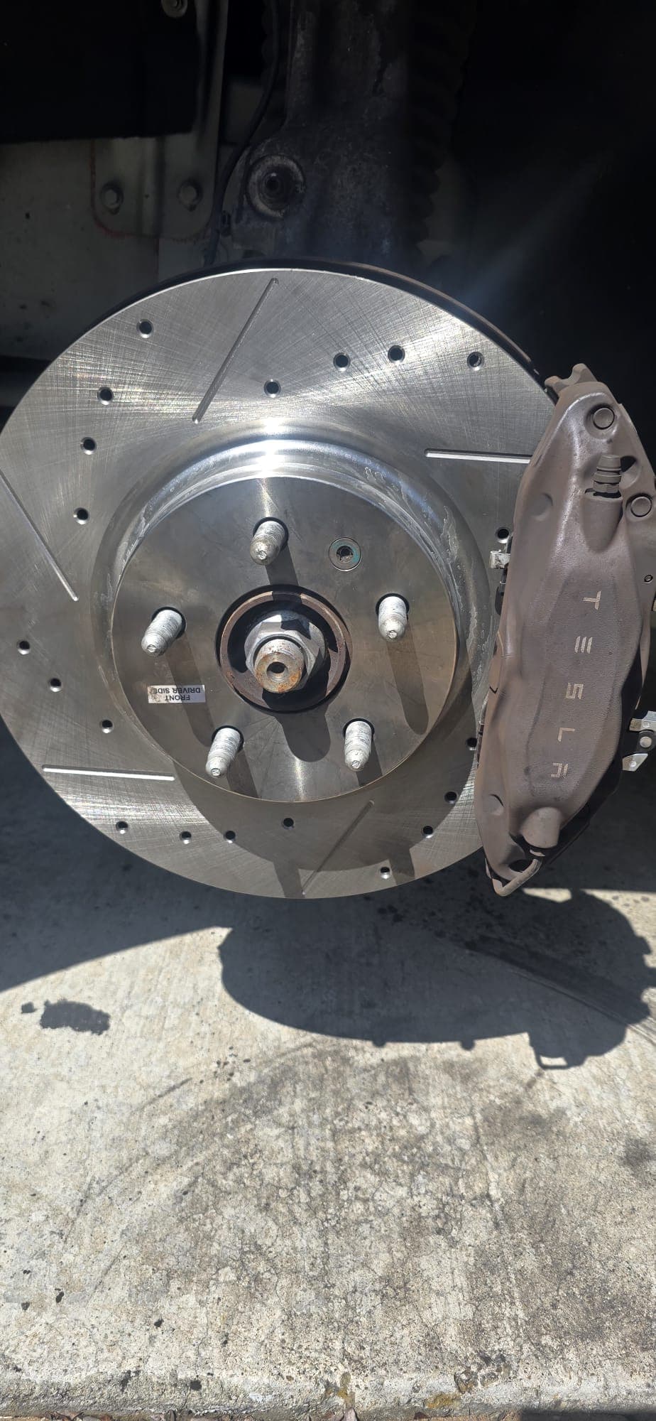 Drilled and slotted brake rotor on a Tesla